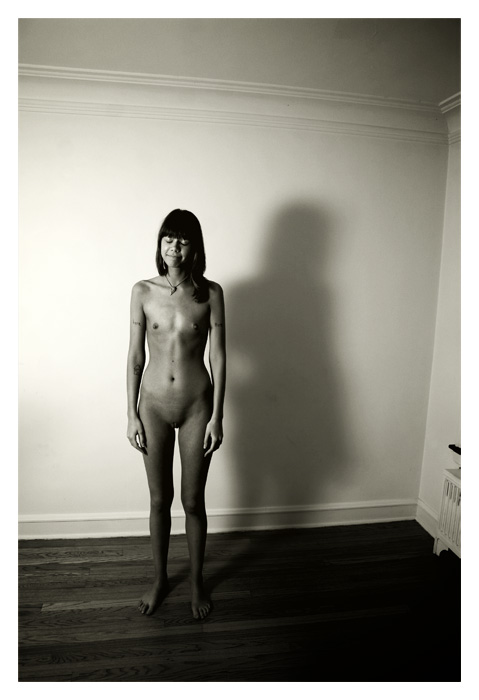 nude woman with tattoos standing
